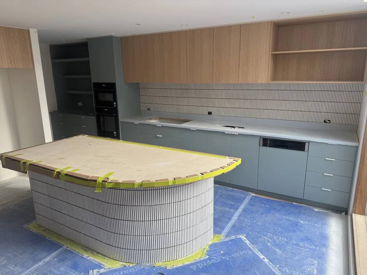 A curved kitchen island clad in finger tiles