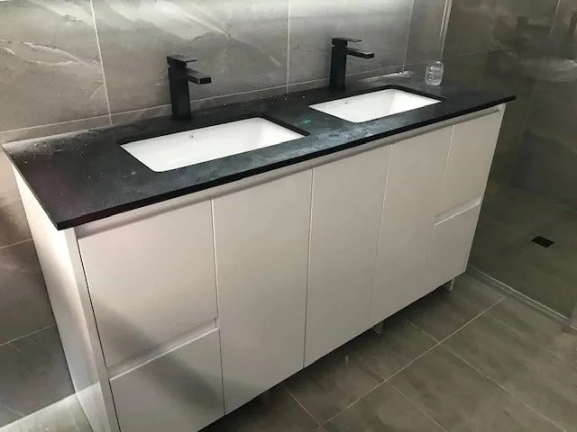 Double vanity with a black stone top and black tapware