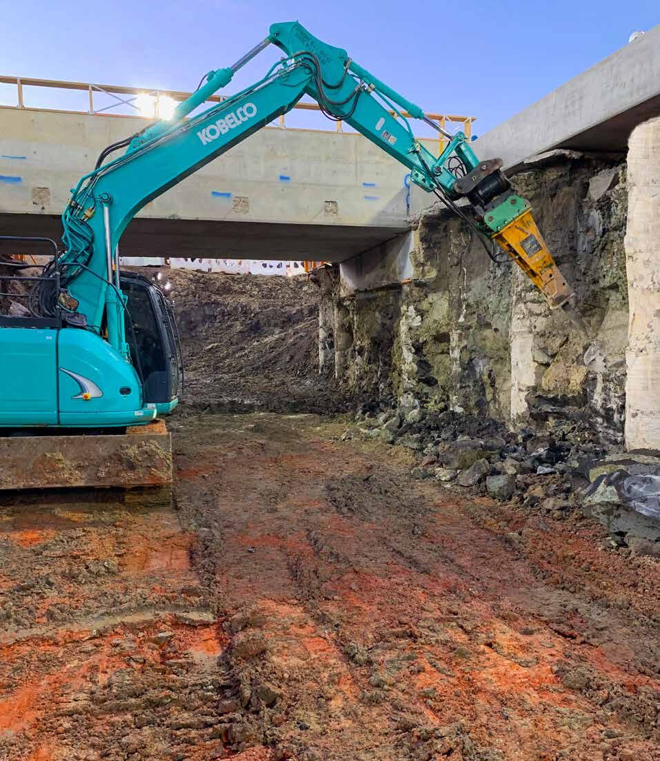 QCS excavator carrying out structural demolition and excavation works beneath a bridge structure