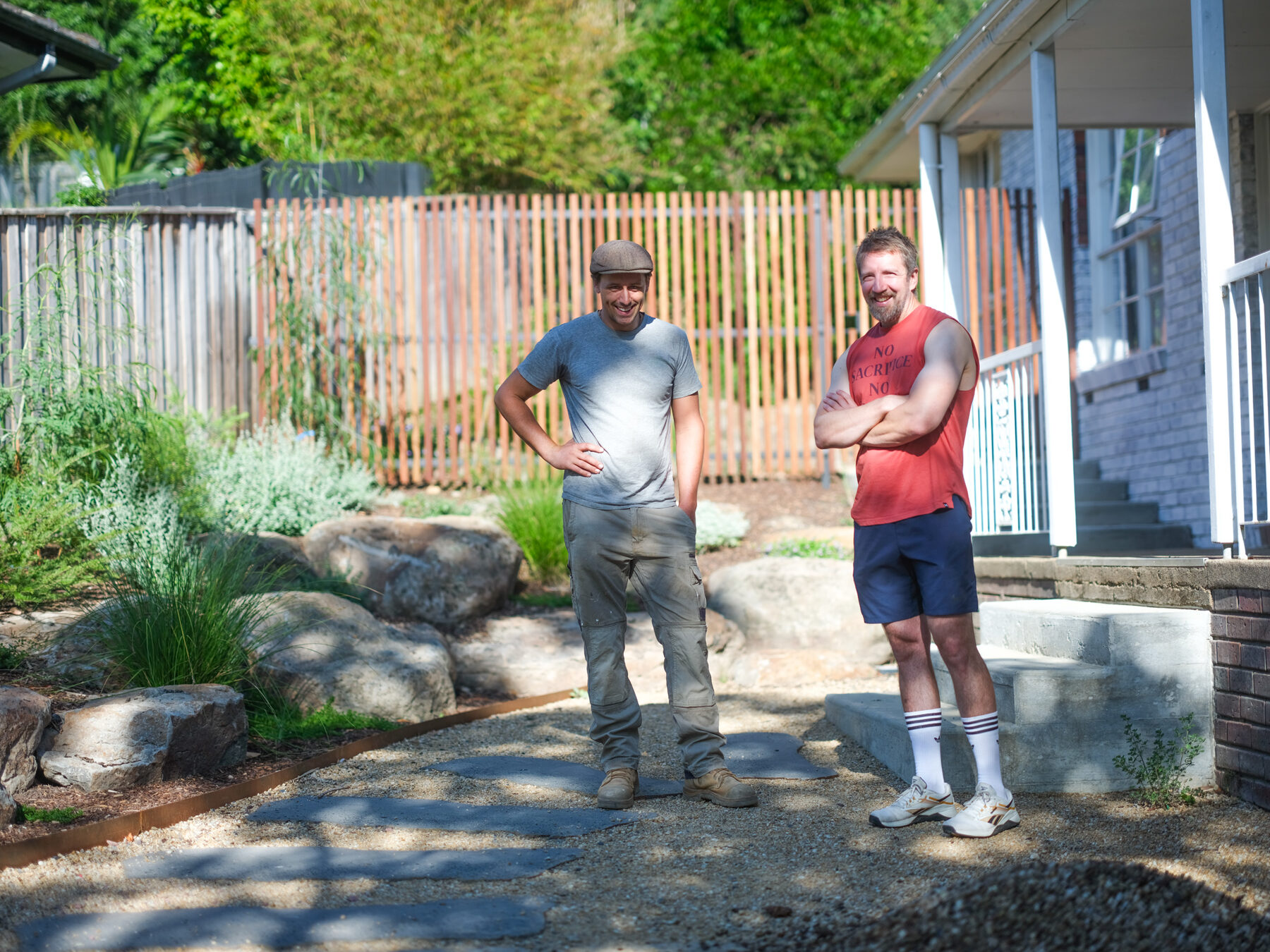Finished gravel courtyard with a hardwood slat fence and rock wall
