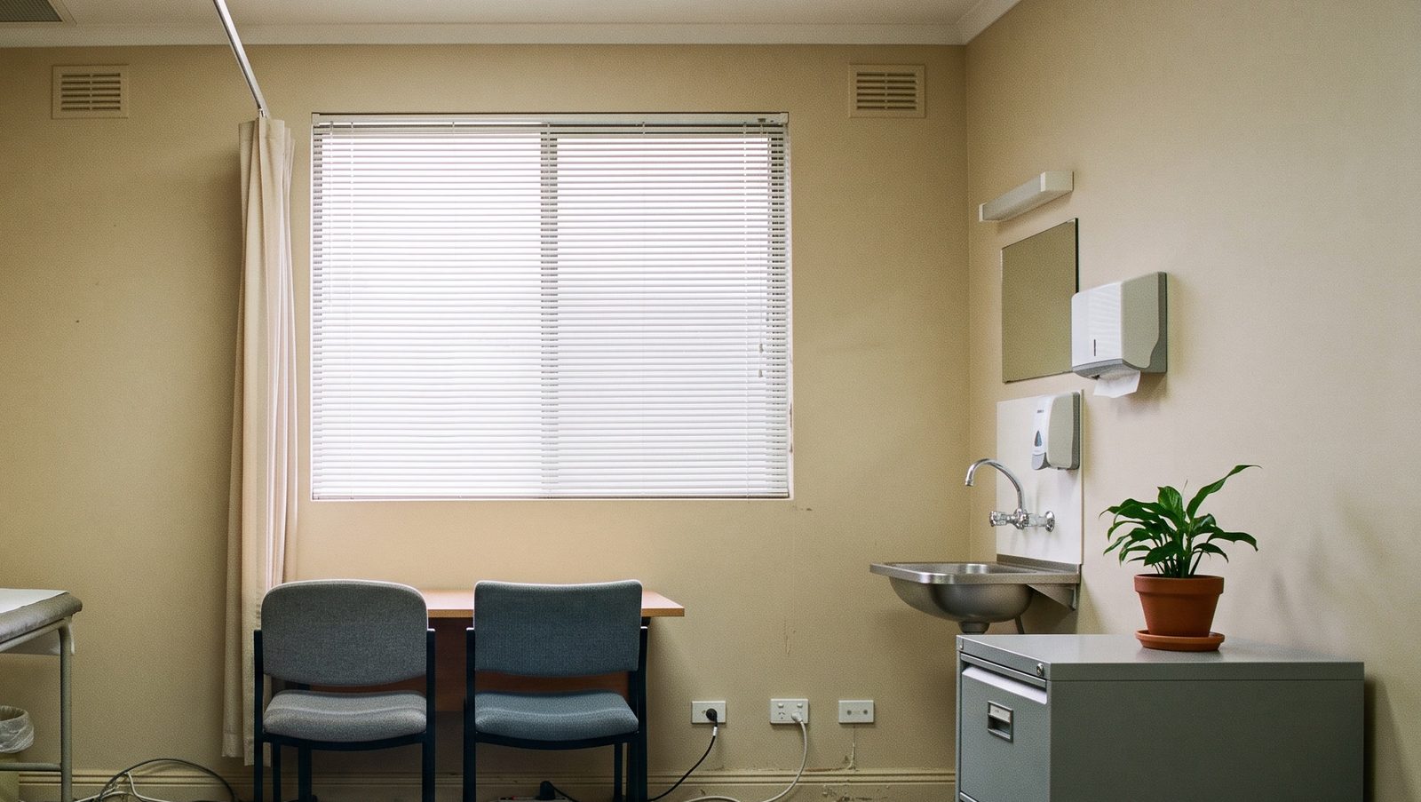 A quiet consulting room with two chairs pulled up to a small table under the window