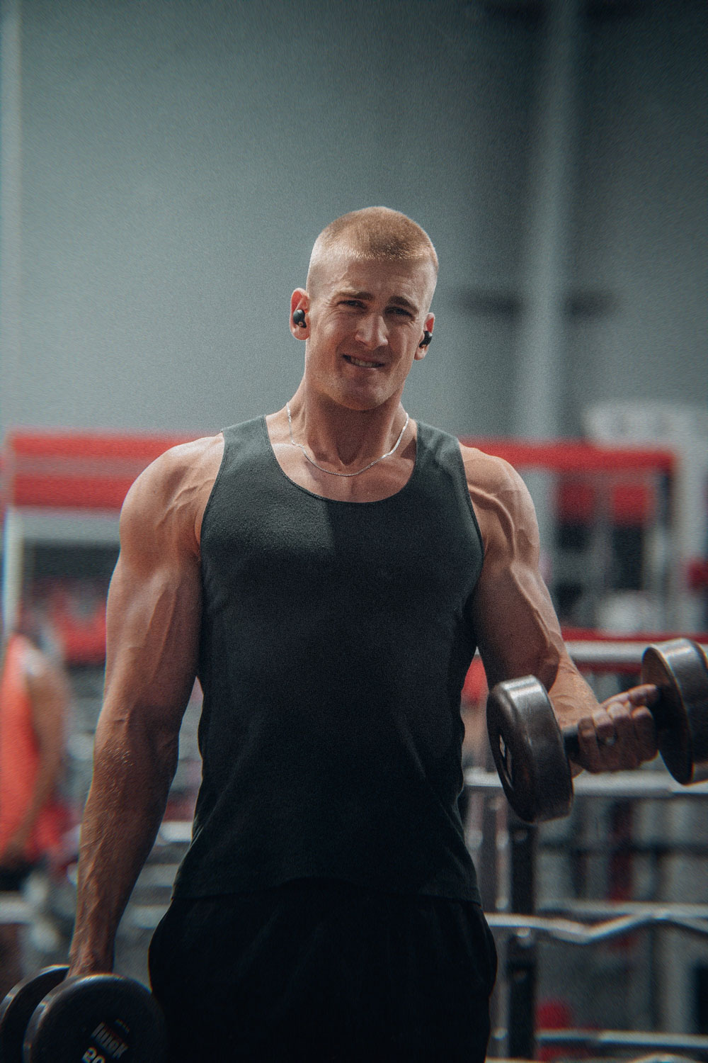Bald muscular man performing a dumbbell curl