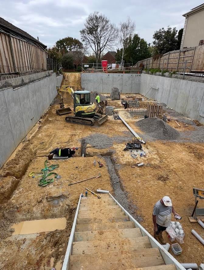 A basement excavation with shotcrete walls and timber lagging