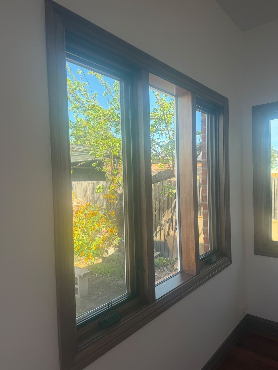 Stained timber window frames looking out to a garden
