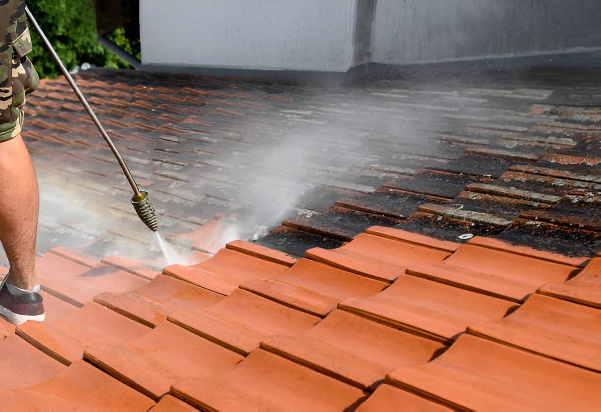 High pressure cleaning stripping grime from roof tiles