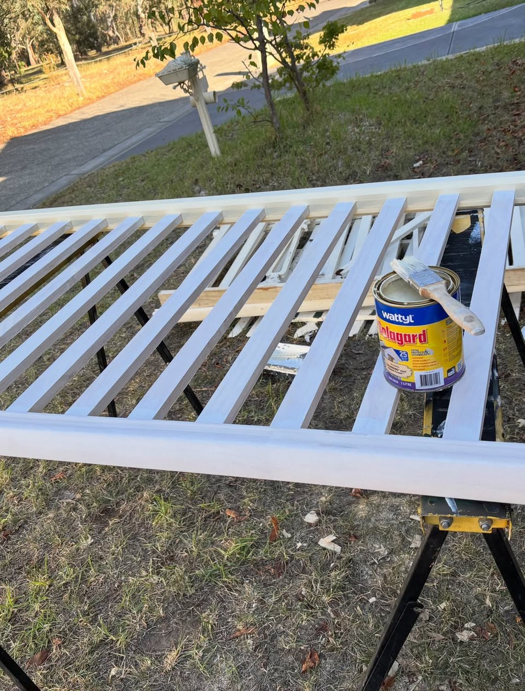 White balustrade sections laid out on trestles part way through painting