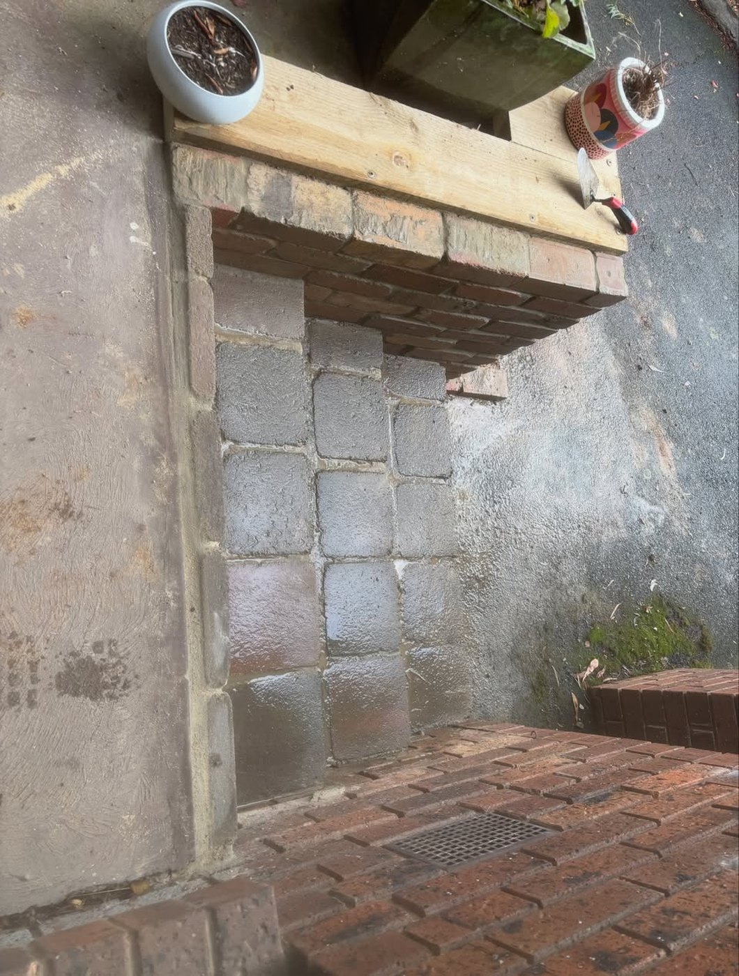 Brick wall with a new timber lintel installed above the opening