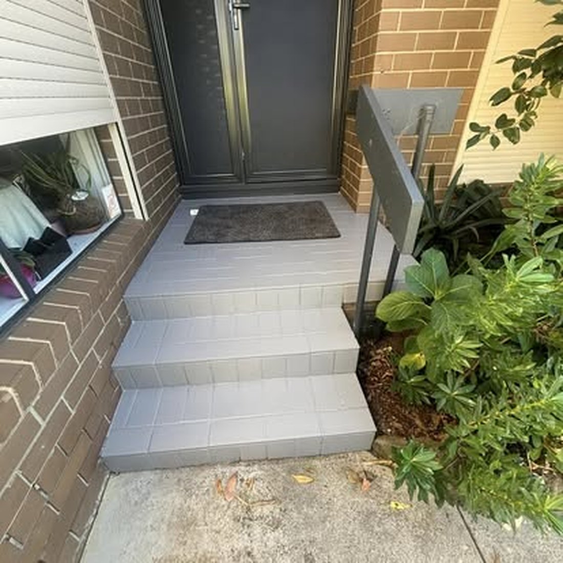 Concrete side path leading to a house entry