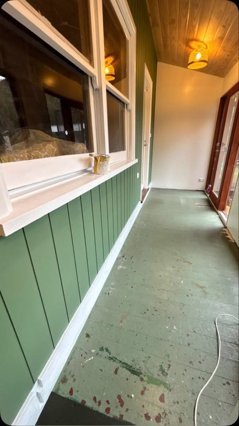 Verandah part way through painting, sage green weatherboards and timber ceiling